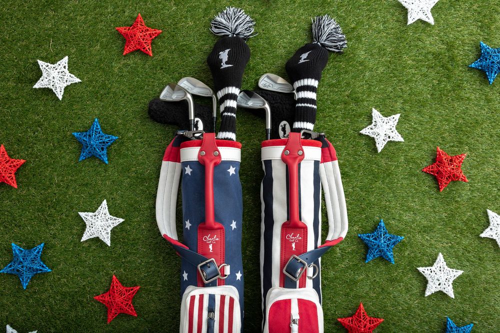 Patriotic red, white, and blue golf bags with star decorations on green turf, perfect for Fourth of July golf outings.