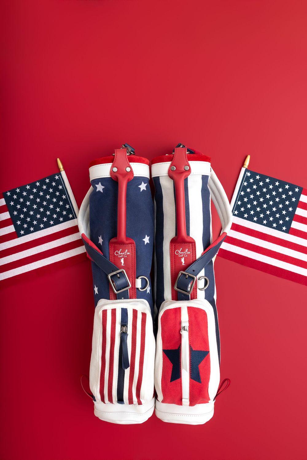Patriotic golf bags with American flag design in red, white, and blue, displayed with small USA flags on red background.