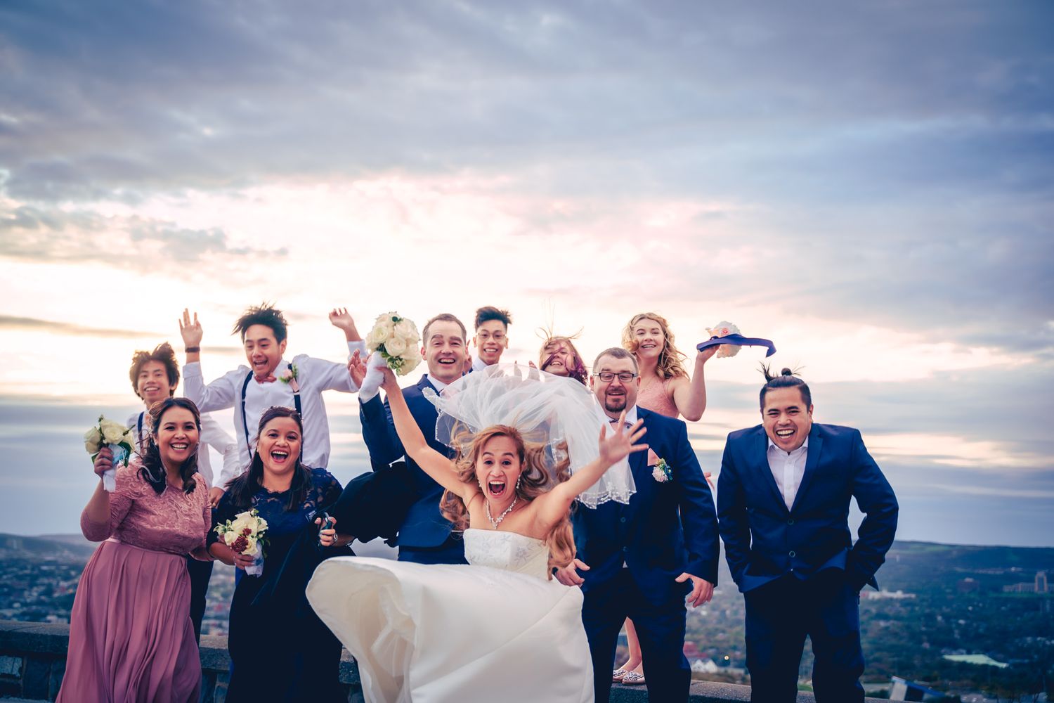 Bride and wedding party screaming in happiness at historic Signal Hill, captured by the best wedding photographer