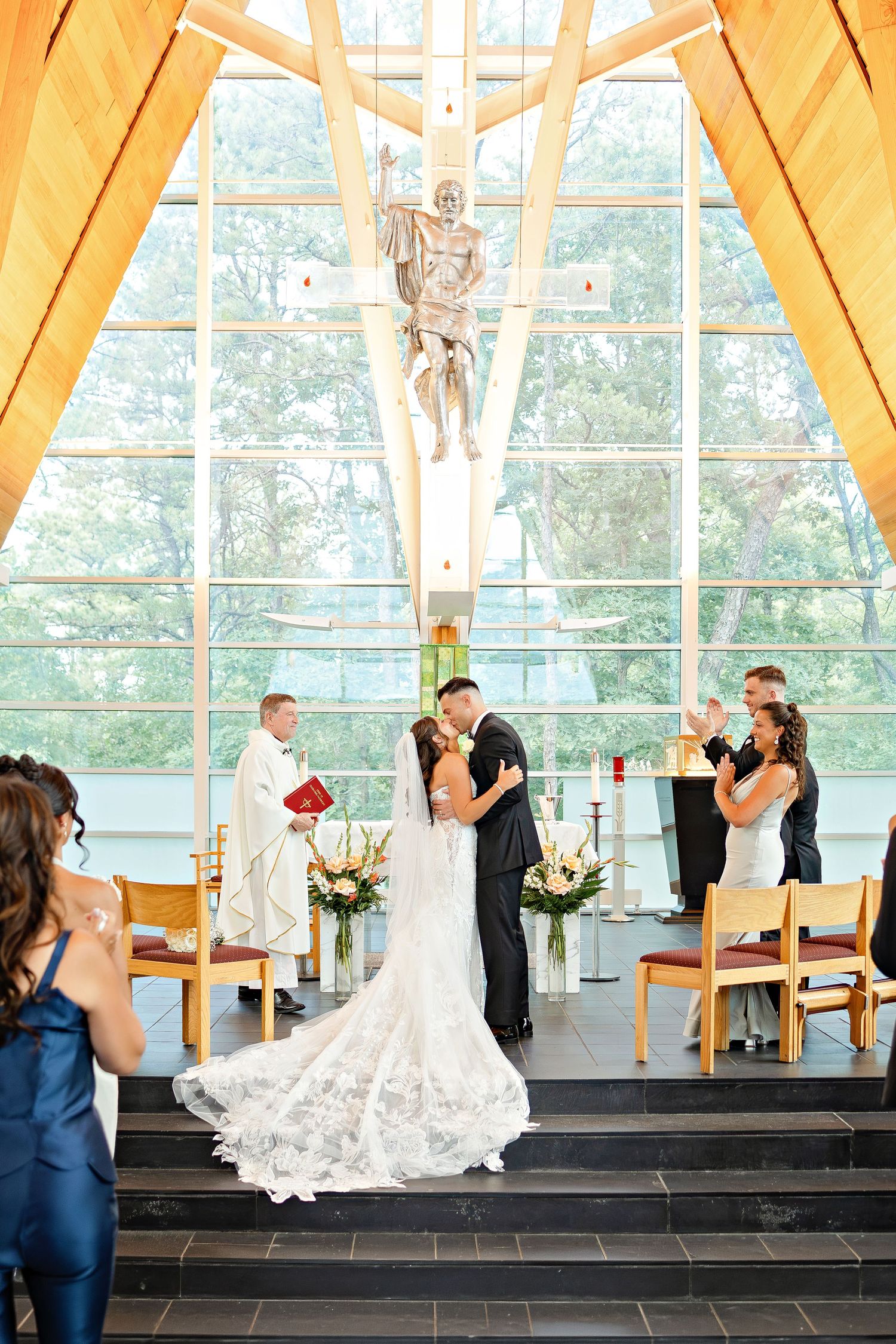A romantic proposal scene set between rows of grapevines in a scenic vineyard with white flowers and a blanket.