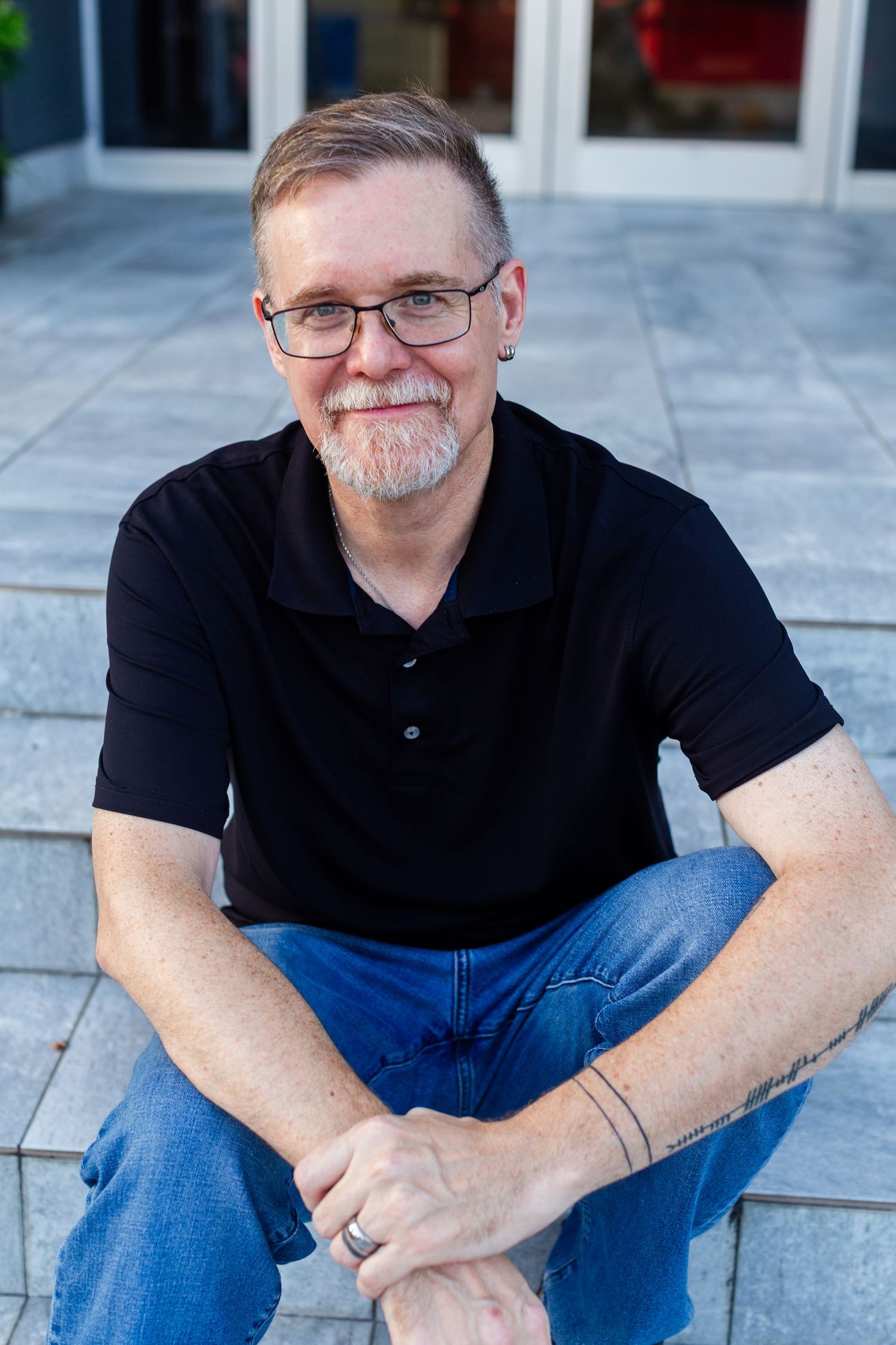 Headshot of a man sitting on gray tiled steps. Guaynabo, Puerto Rico.