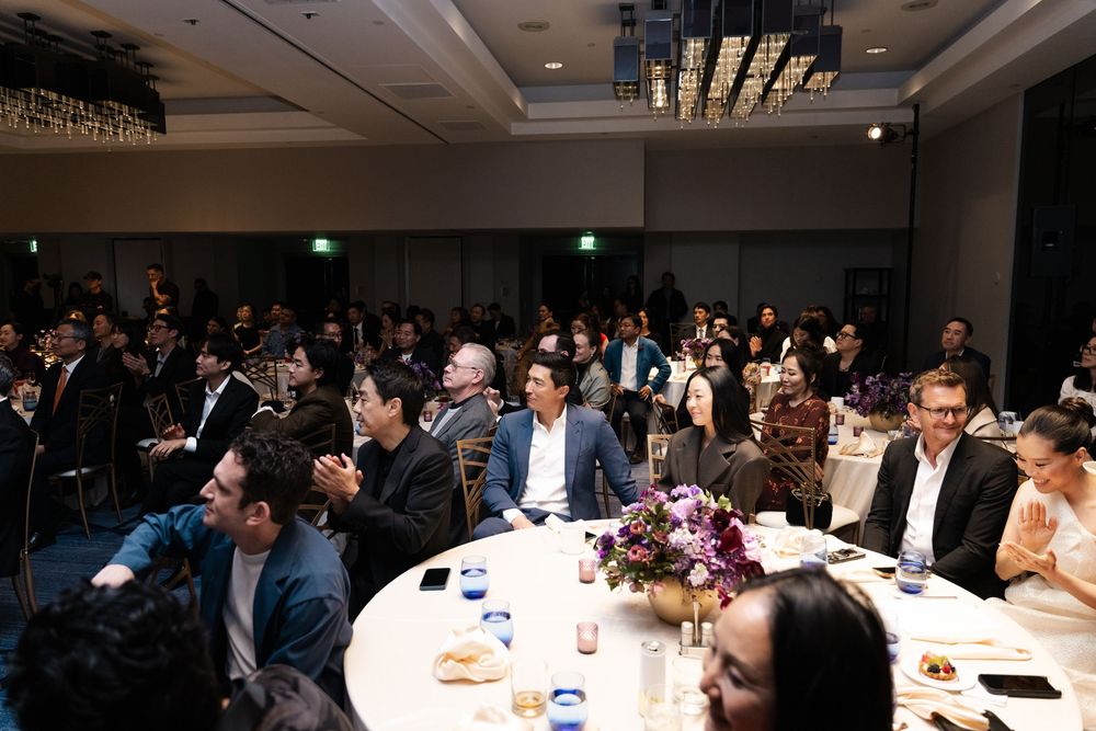 Guests seated at round tables during a formal banquet event in an elegant ballroom setting.