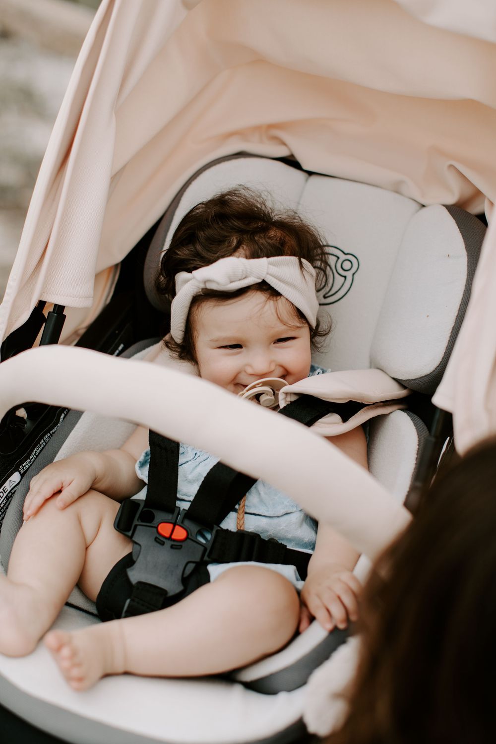 Child resting comfortably in a white modern car seat.