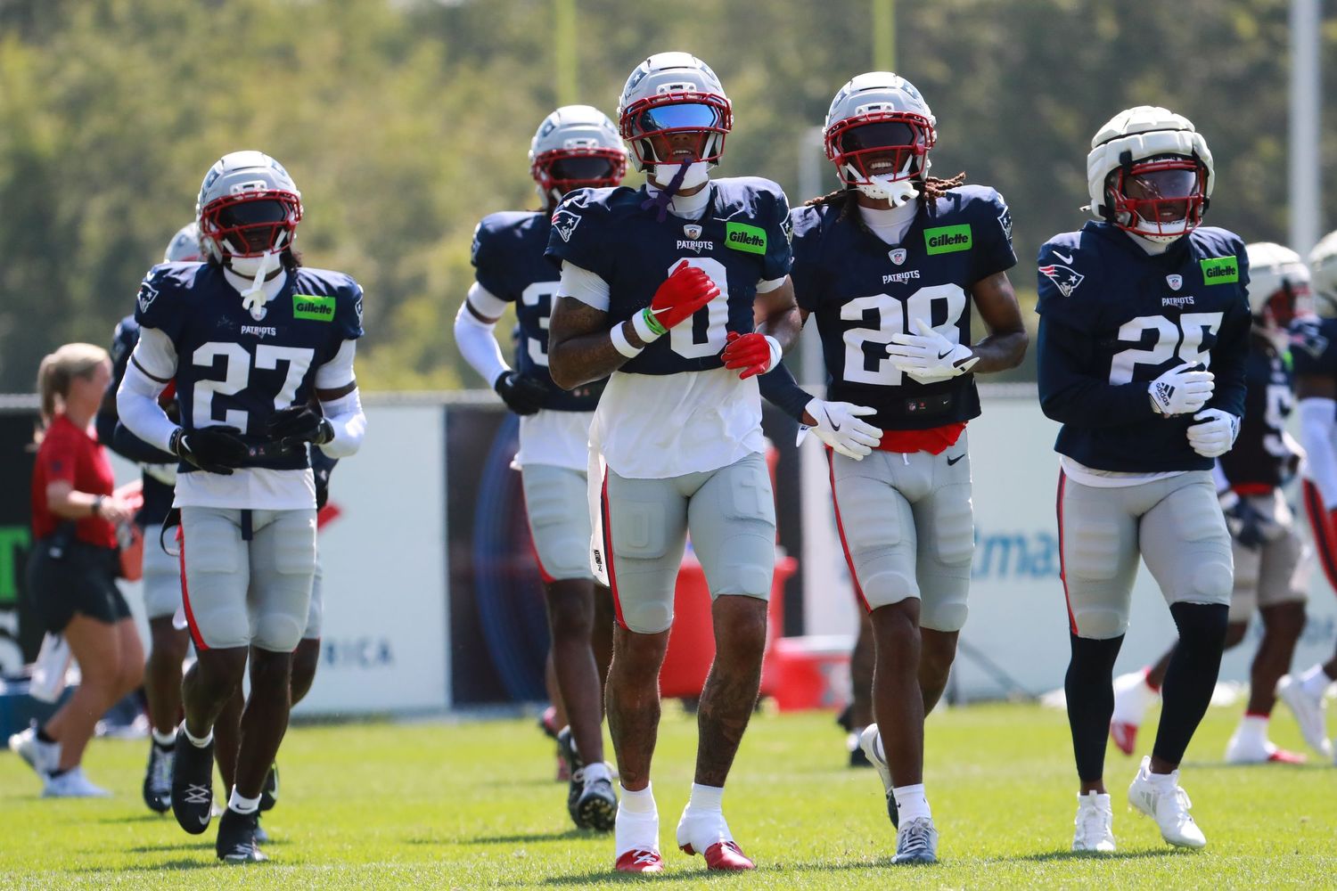 Football players in navy and white uniforms lined up during practice.