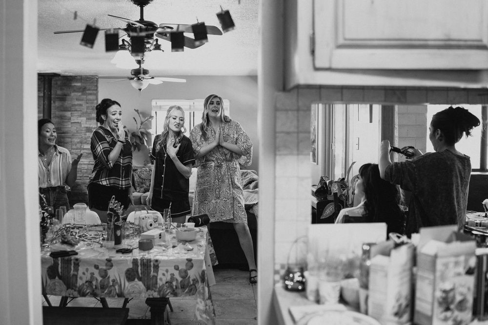 Black and white photo of women gathered around a table at an indoor party or social event.