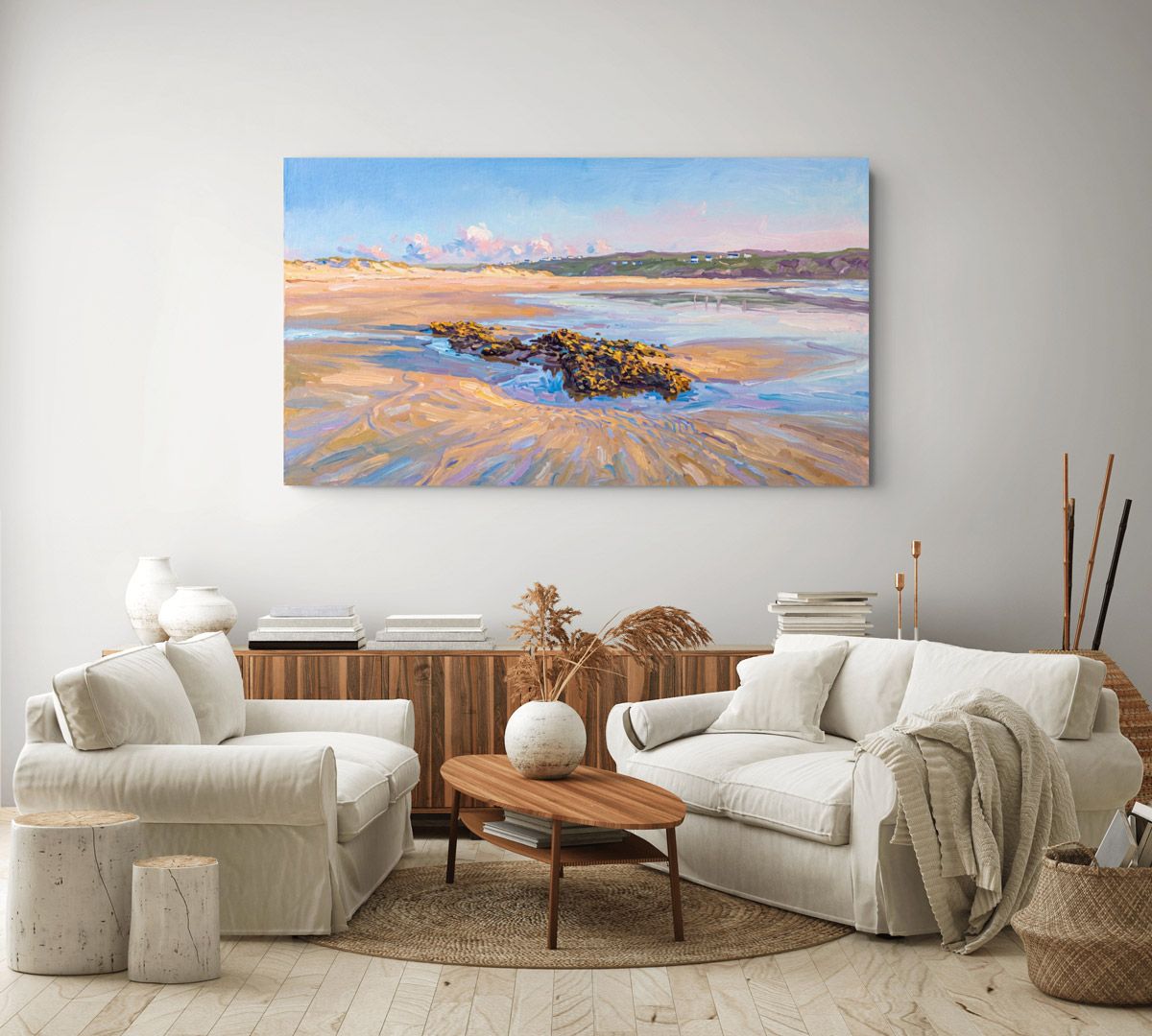 Impressionist beach landscape painting displayed on wall above white sofas and wooden coffee table in a bright living room.