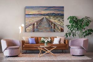 Oil painting of a wooden boardwalk stretching to a sunset horizon, displayed above a modern living room sofa.