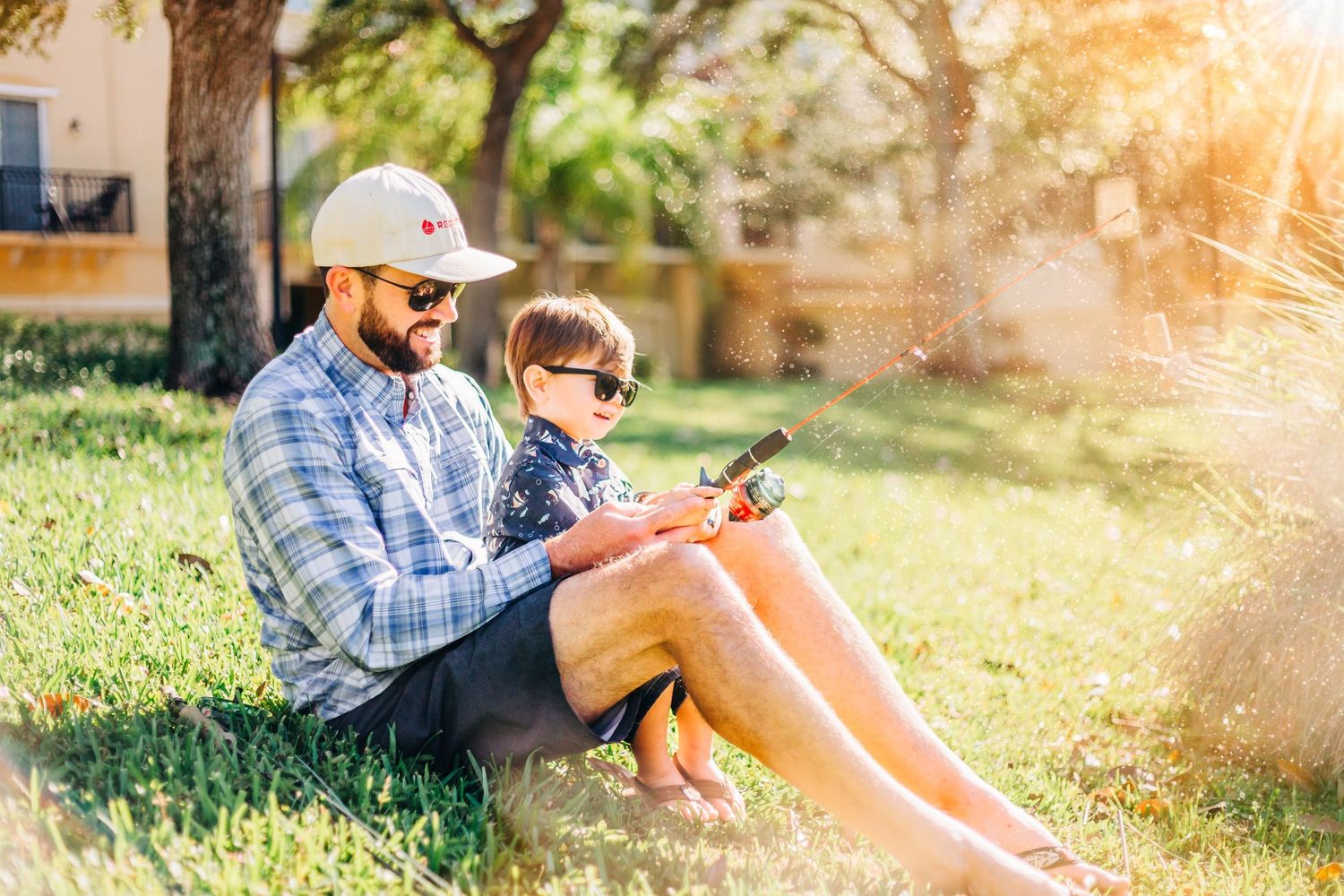 Father fishing with his toddler son in magic glowing sun light in wellington Florida by Photogenic Fox Photography