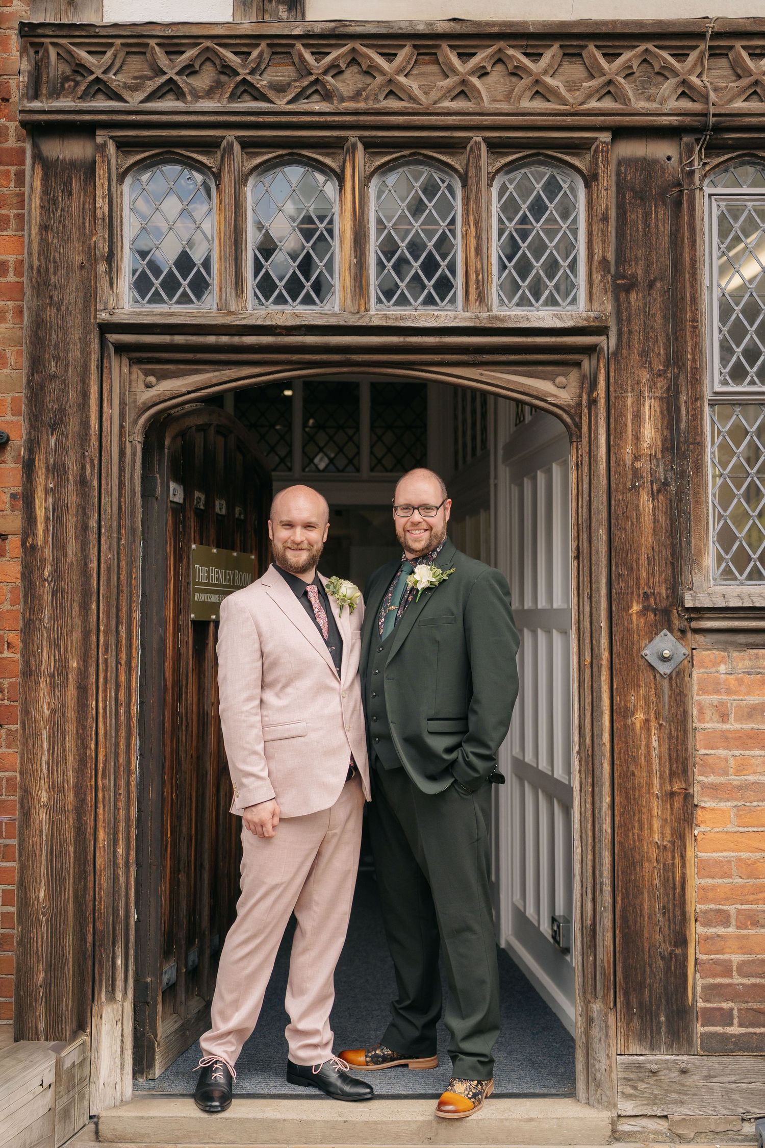 Newlywed couple walks hand-in-hand down the aisle as guests applaud in a rustic wedding venue.