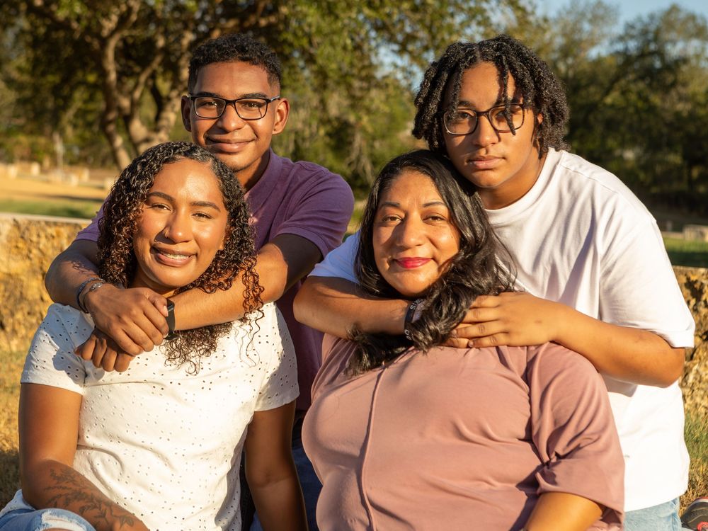 Group Family Photography posing close together outdoors at Webberville Park in Webberville,TX.