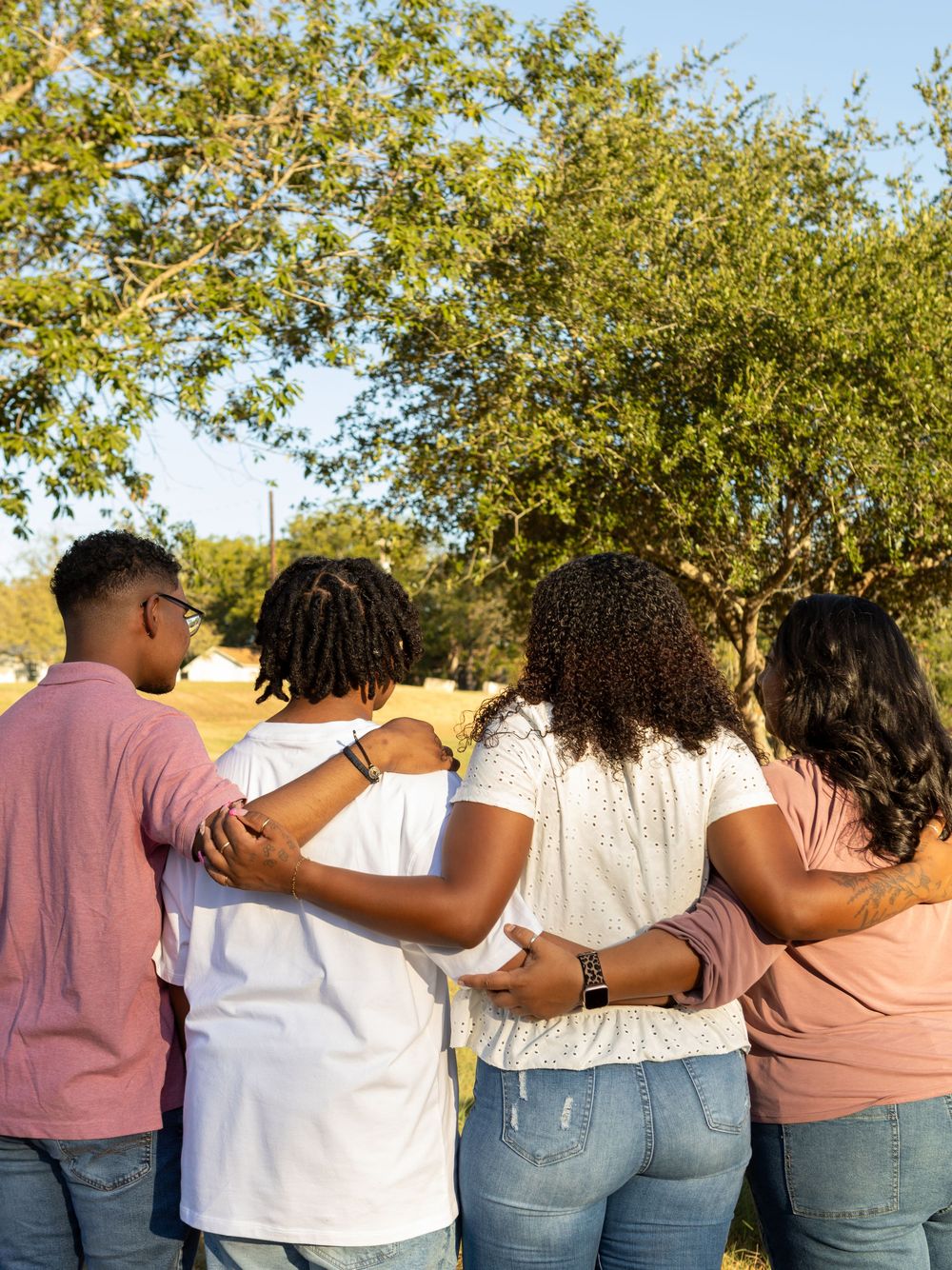 Family Photography of the family hugging from behind at webberville park in webberville, TX