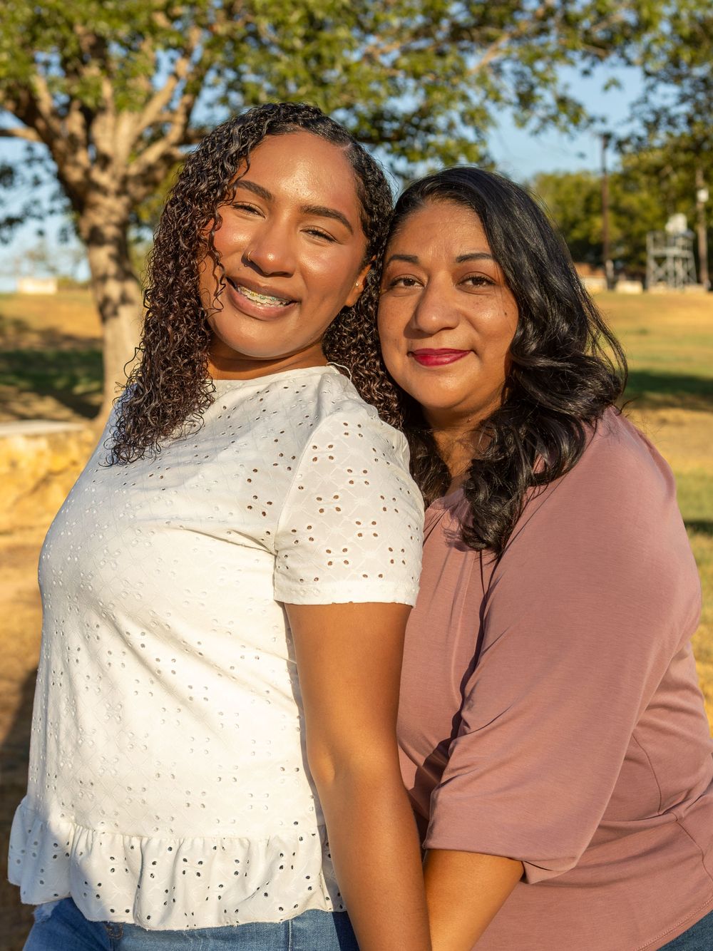 Mother and daughter posing close together outdoors at Webberville Park.