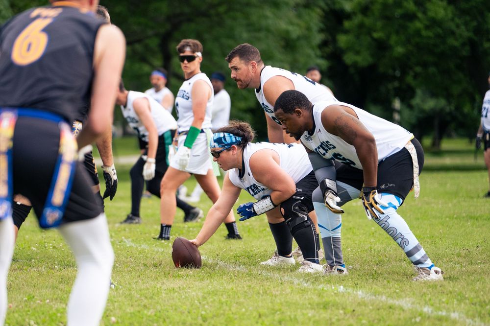 A football team is ready at the line of scrimmage on the field at Pride Bowl hosted by NGFFL in Chicago