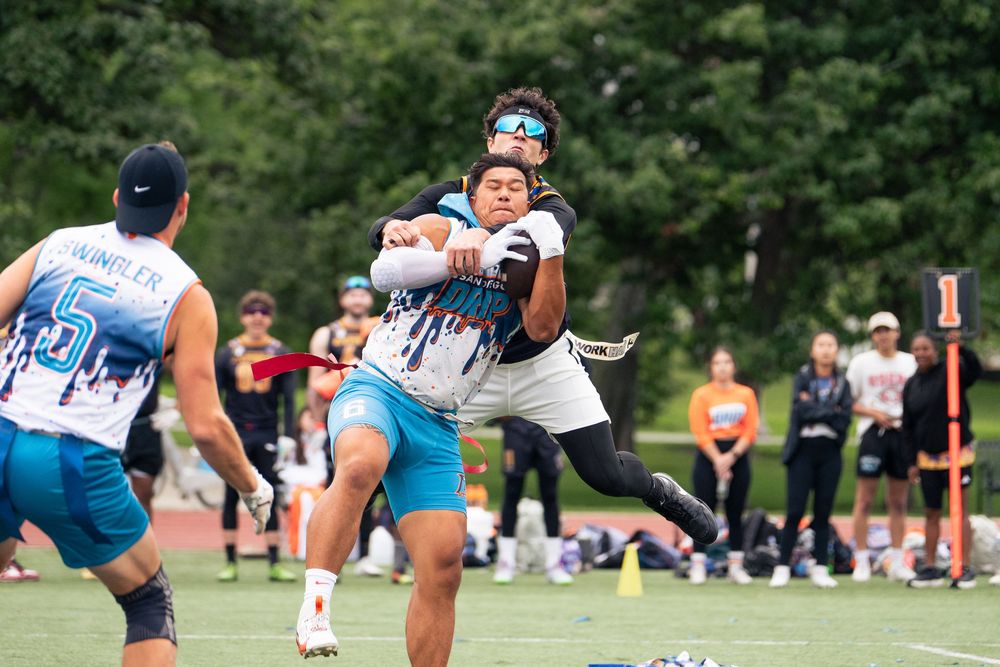 Two flag football athletes make a play for the thrown football at Pride Bowl hosted by NGFFL in Chicago