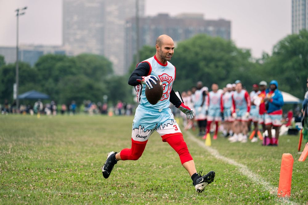 A Chicago flag football athlete runs with the ball across the endzone line at Pride Bowl hosted by NGFFL in Chicago