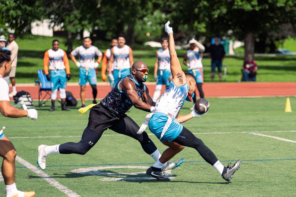A Chicago football athlete pulls a flag of a San Diego player carrying the ball to stop the play at Pride Bowl hosted by NGFFL in Chicago