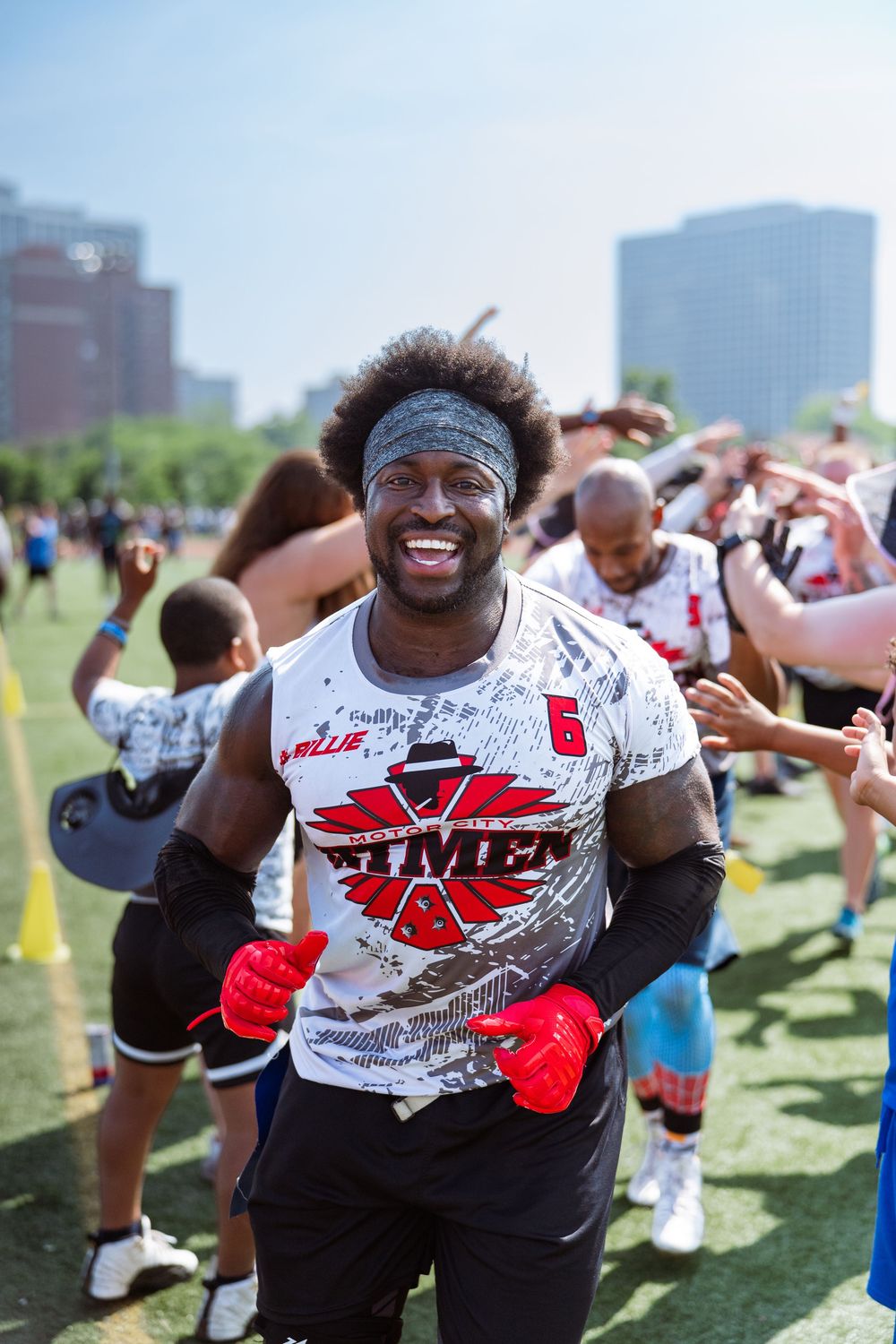 A football player from Michigan celebrates a championship at the end of a tunnel of fans at Pride Bowl in Chicago, hosted by NGFFL