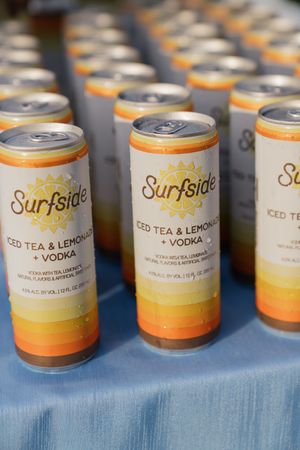 Rows of Surfside Iced Tea Lemonade and Vodka canned cocktails displayed on a blue tablecloth.