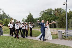 Bride and groom lead a festive second line parade with a brass band at their wedding.