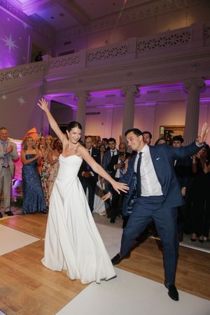 Bride and groom make grand entrance onto dance floor at elegant wedding reception venue.