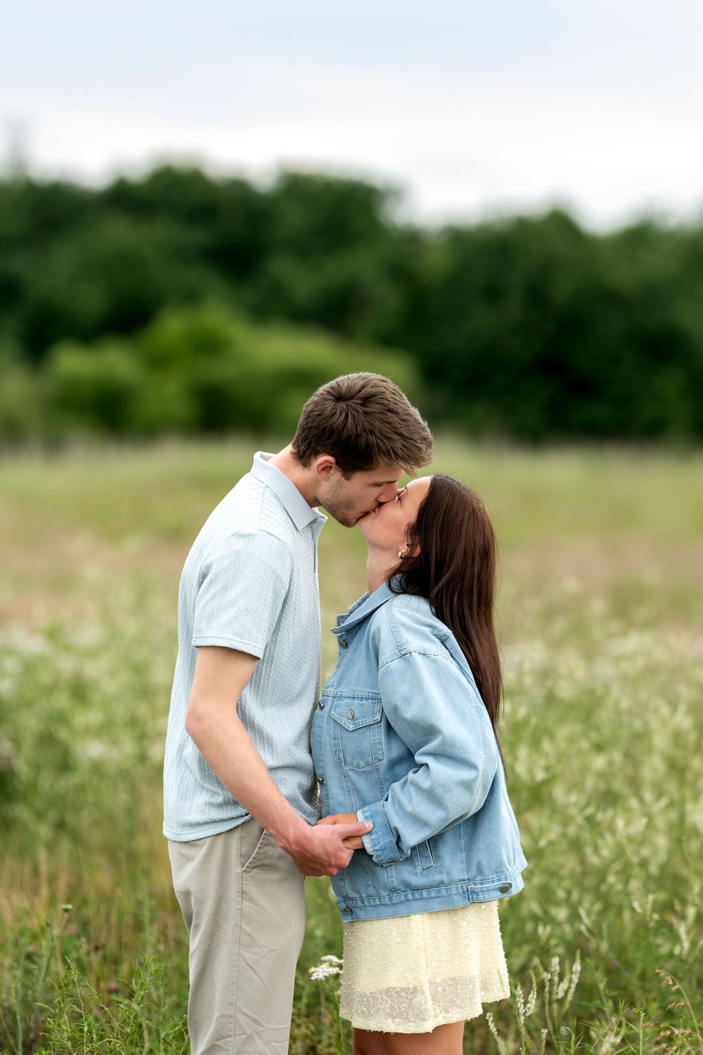 A loving couple shares a kiss in a beautiful wildflower meadow.