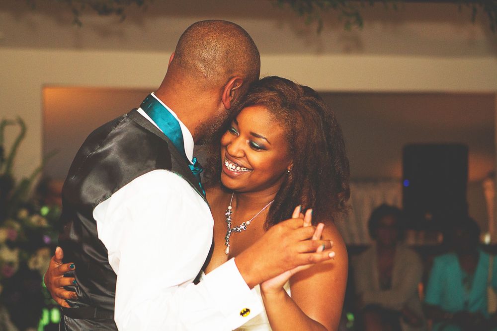 Couple sharing a romantic first dance at their wedding reception, smiling joyfully in elegant attire. At Oaks farm wedding venue in Surrey.