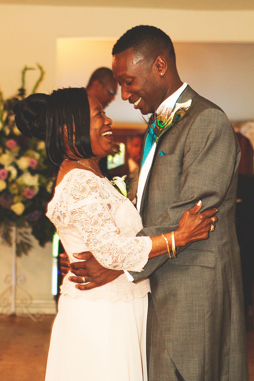 A joyful bride and groom share their first dance, smiling at each other during their wedding reception. At Oaks farm wedding venue in Surrey