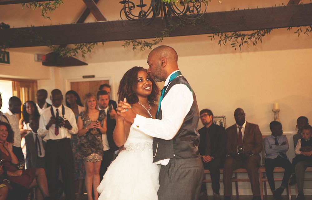 Bride and groom share their first dance at wedding reception, surrounded by guests in elegant venue. At Oaks farm wedding venue in Surrey.
