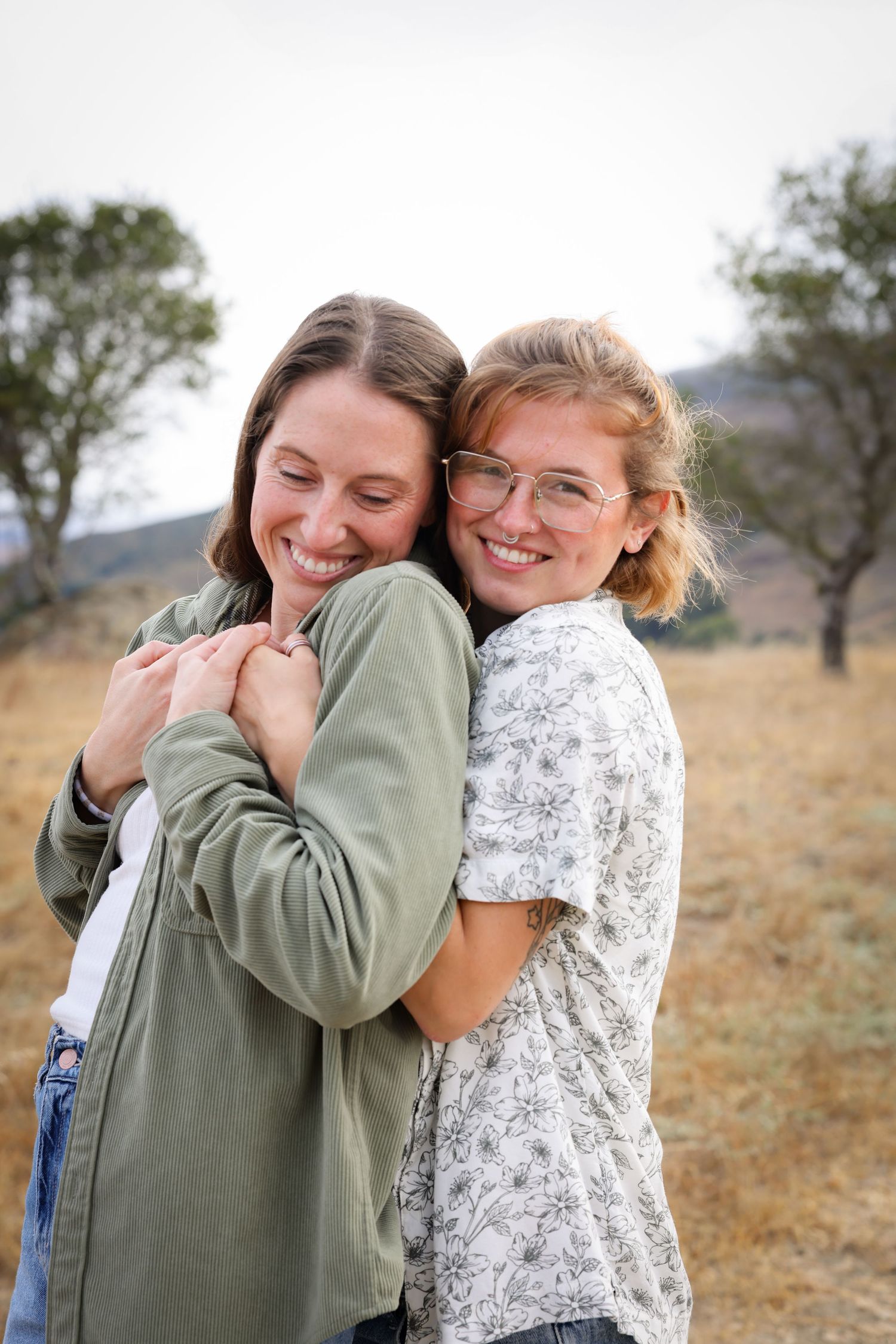 Two women embrace in a romantic picture in trees in San Luis Obispo couples portrait session