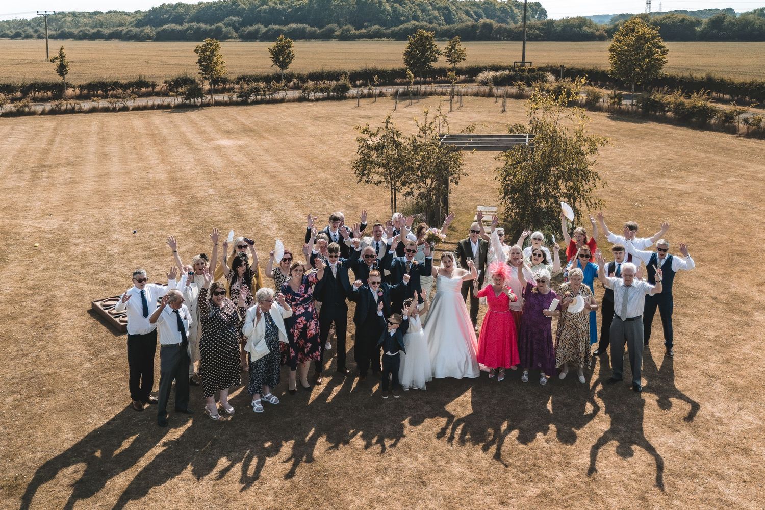 Aerial photo of the wedding party group shot in the grounds of a wedding venue