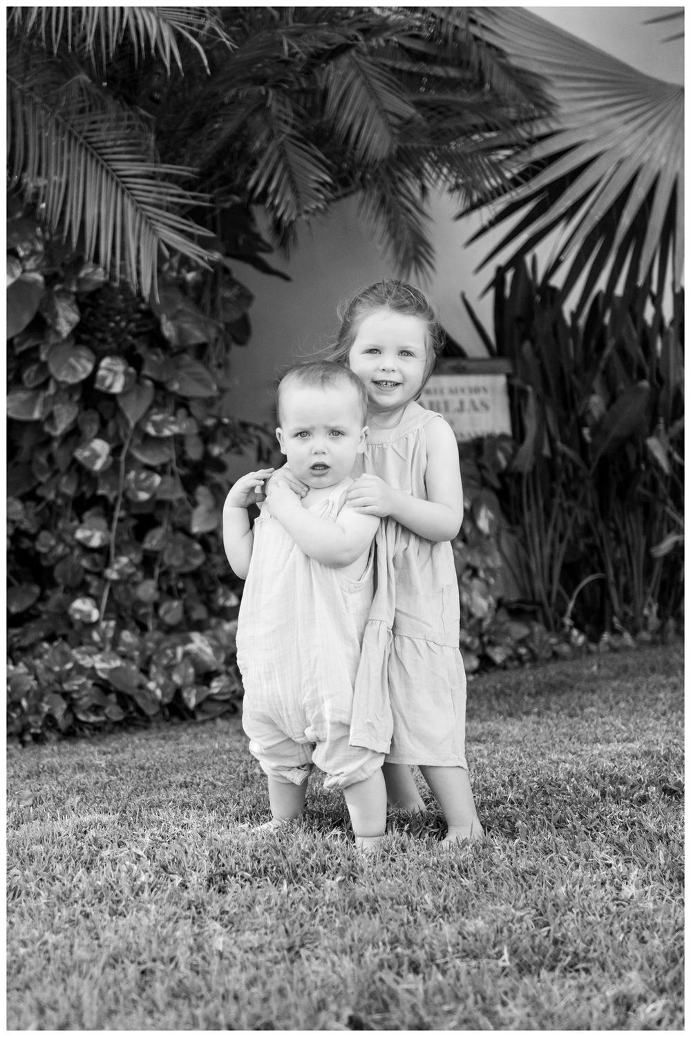 Grand Velas Riviera Nayarit Family Photographer capturing two siblings sharing a joyful embrace during candid family photos.