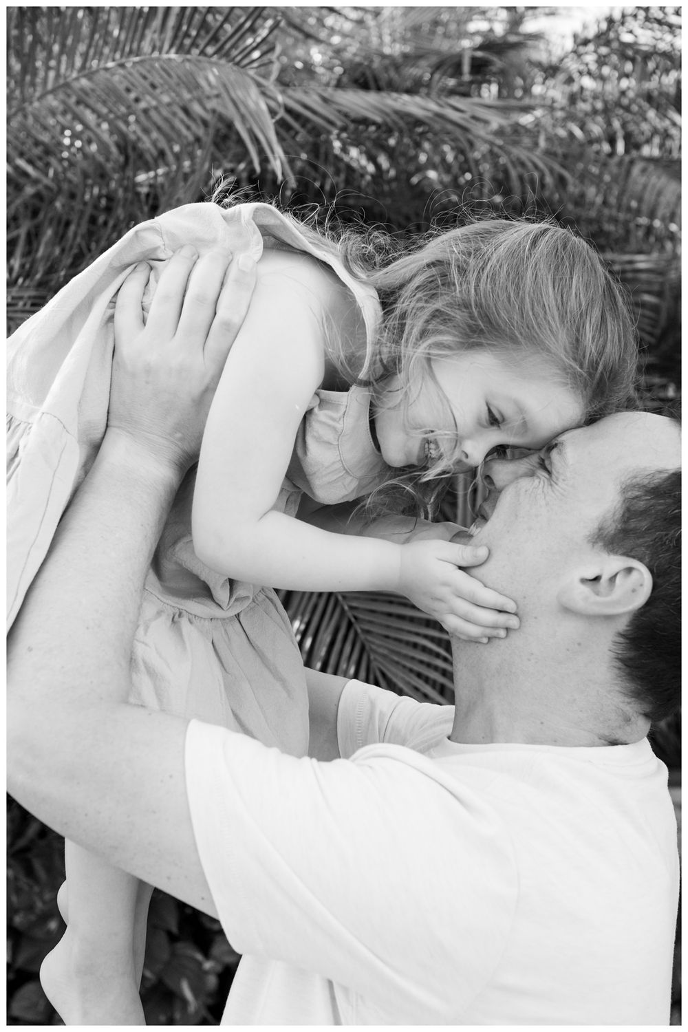 Grand Velas Riviera Nayarit Family Photographer capturing a father lifting his daughter during a joyful family photo session outdoors.