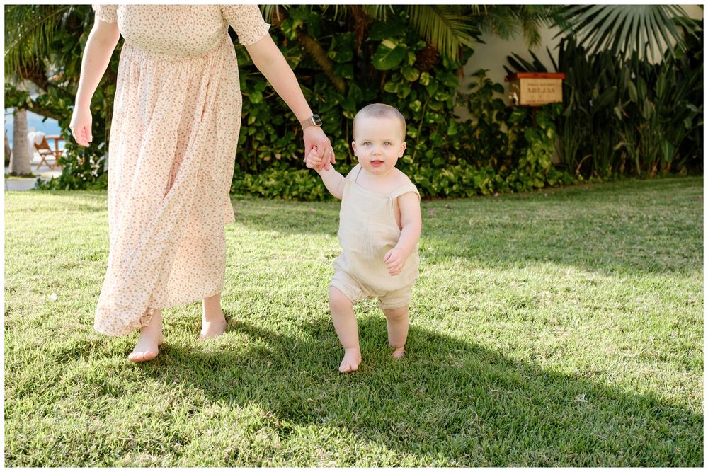 Grand Velas Riviera Nayarit Family Photographer capturing a toddler taking first steps during lifestyle family photo session.