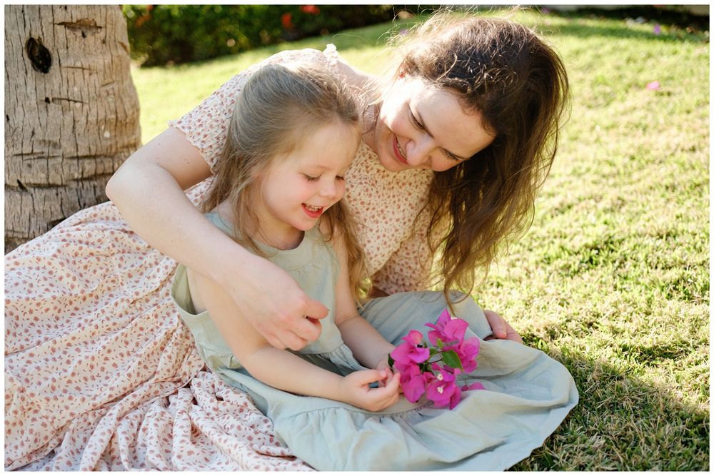 Grand Velas Riviera Nayarit Family Photographer capturing a mother and daughter in a sunny garden during family portraits.