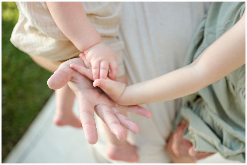 Grand Velas Riviera Nayarit Family Photographer capturing a parent and child connection through gentle touches during candid family photos.