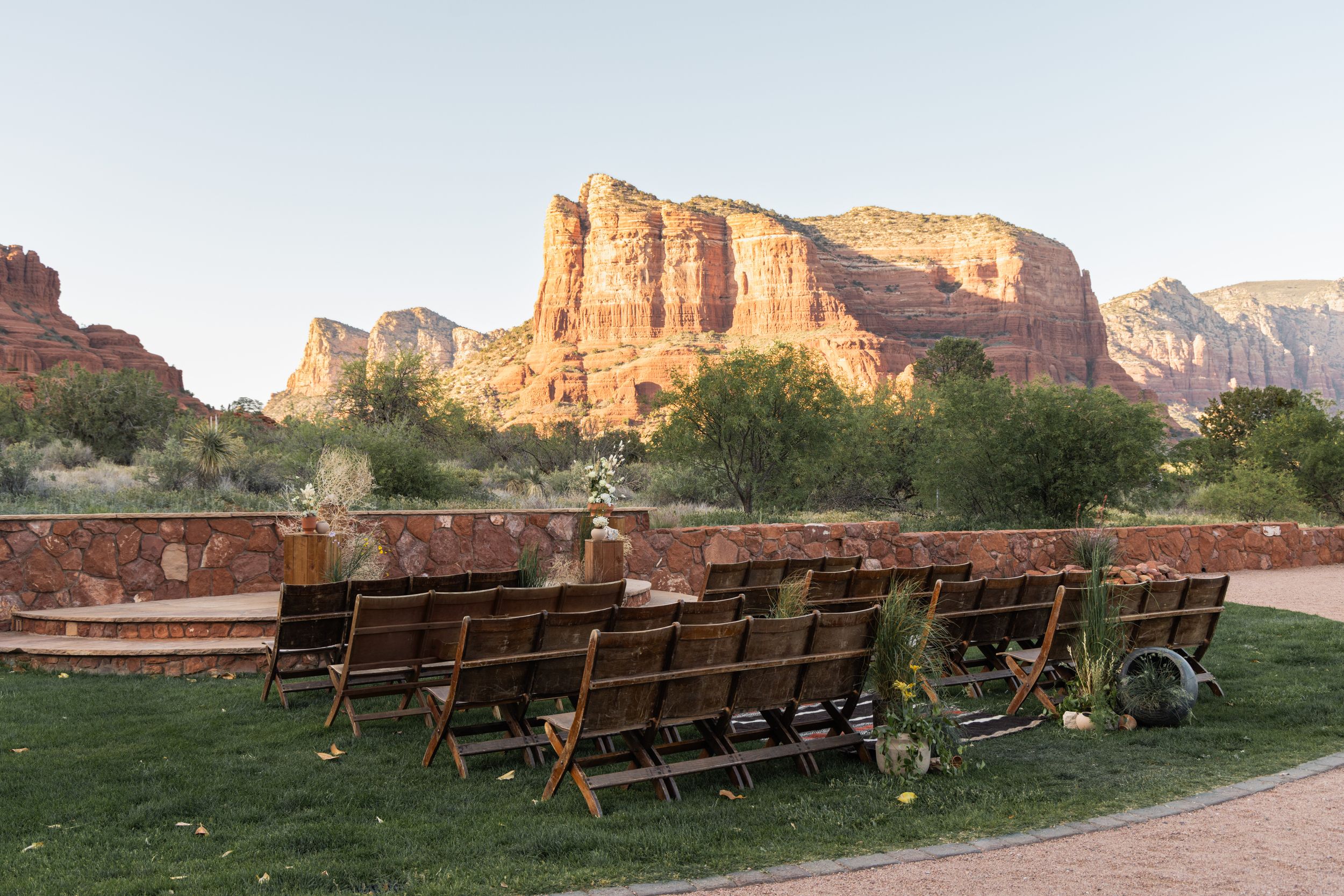 Wooden benches arranged outdoors facing red rock formations in Sedona, Arizona, set up for an outdoor event.