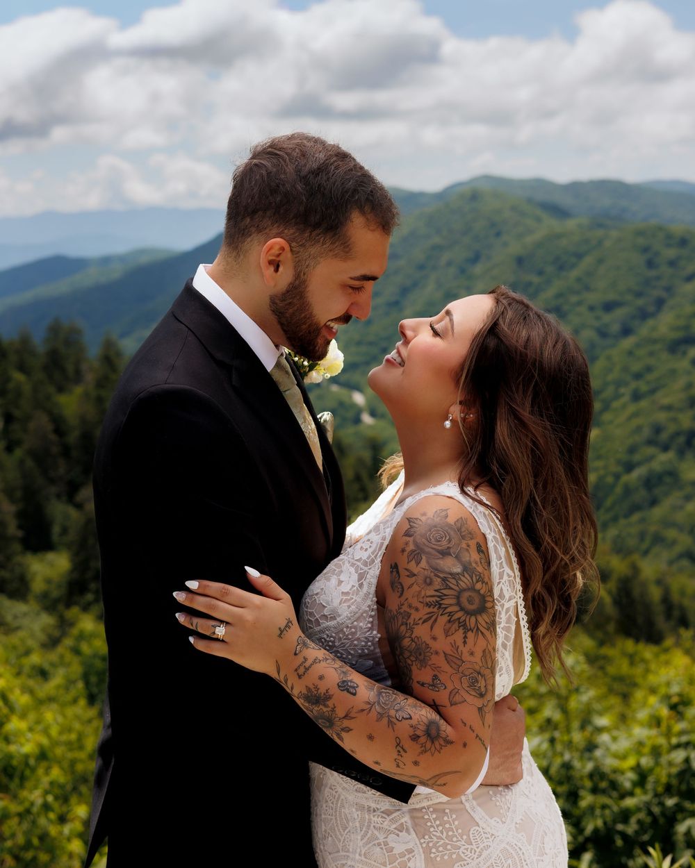 Tattooed bride and groom share a romantic moment with scenic Smoky Mountain backdrop on their wedding day.