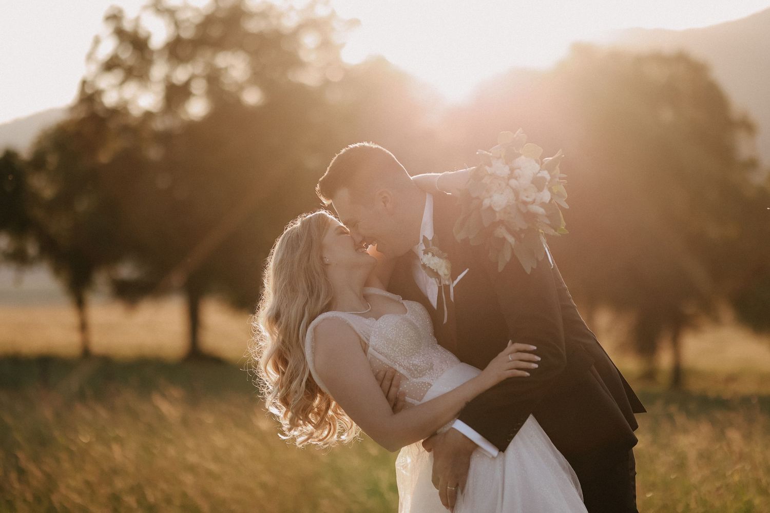 Romantický bozk novomanželov pri západe slnka. Profesionálny svadobný fotograf Rajecké Teplice zachytáva emócie, Rajecká dolina.