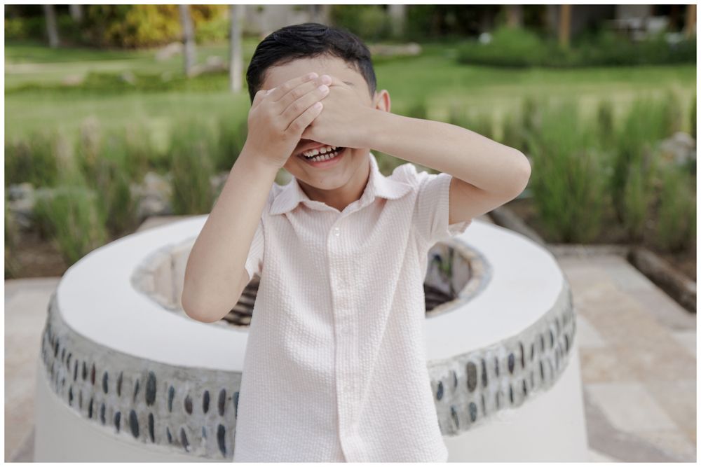 St Regis Punta Mita Family Photographer capturing a playful outdoor portrait near a stone fountain during Beach Family Photo Session.