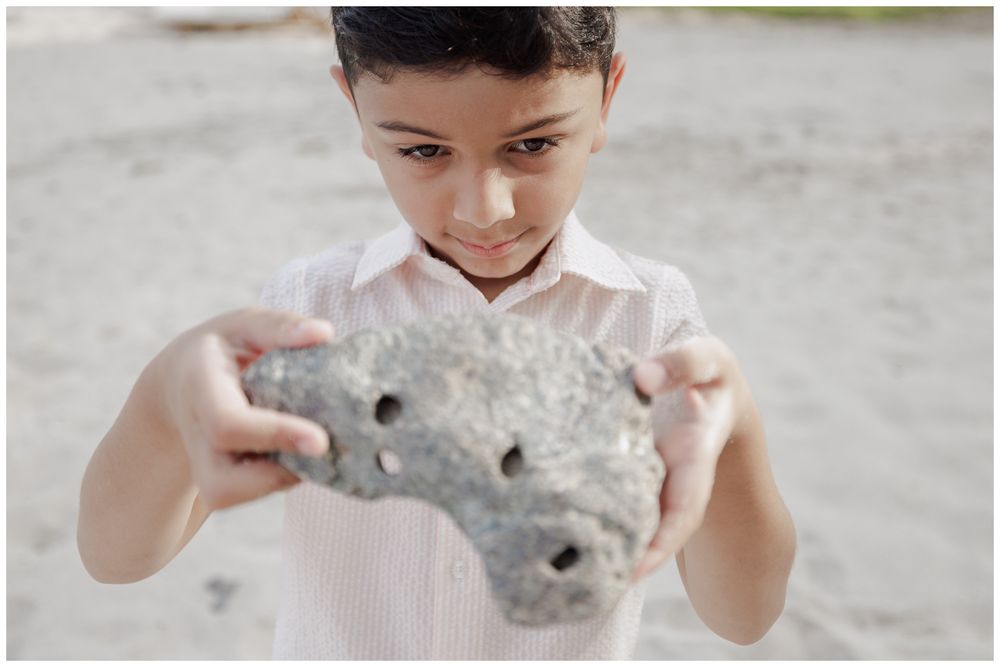 St Regis Punta Mita Family Photographer capturing a boy exploring a porous beach rock during Punta Mita Family Photos.