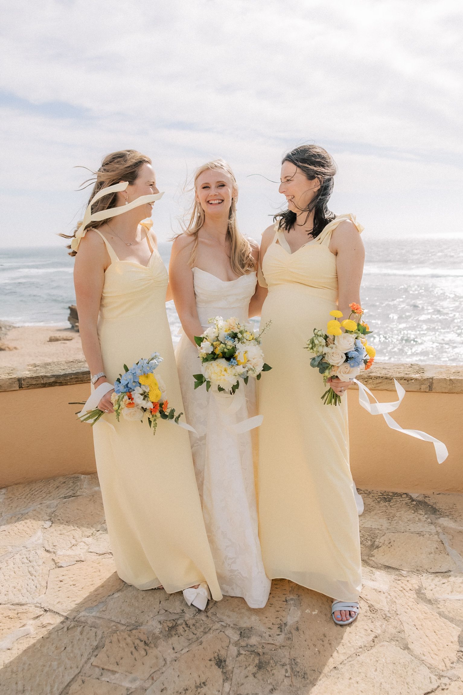Elegant bride and bridesmaids portraits overlooking the Atlantic Ocean after the wedding ceremony in Cascais.