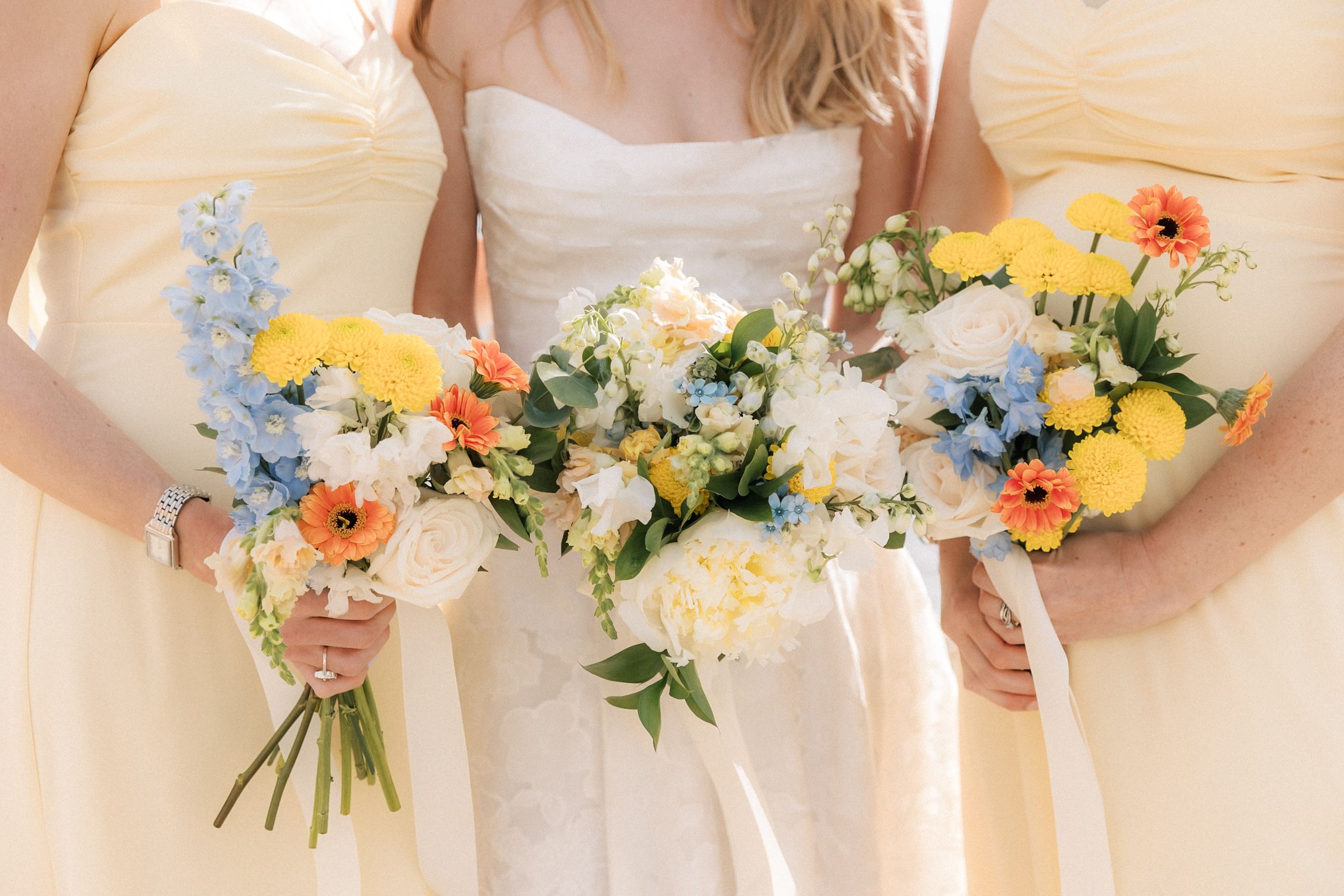 Colourful bridesmaids bouquets featuring seasonal flowers for a coastal destination wedding in Cascais, Portugal.