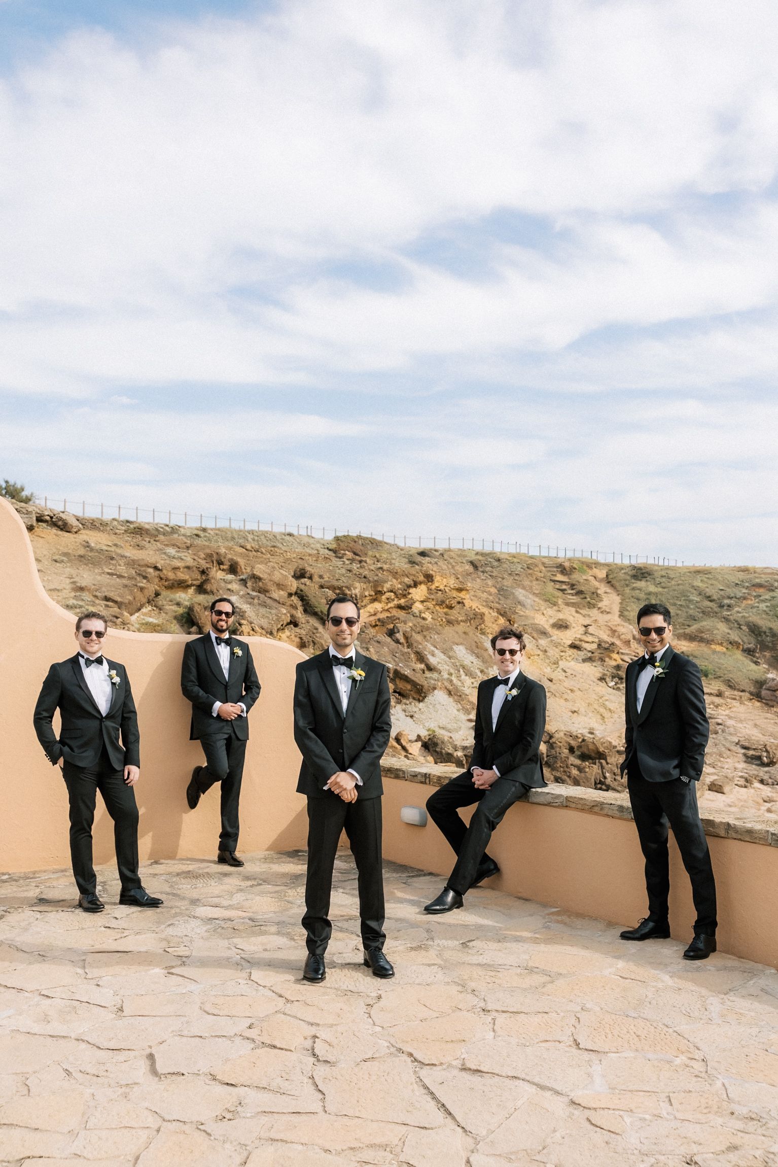 Groom and his groomsmen posing outside Arriba by the Sea before an elegant destination wedding in Cascais, Portugal.
