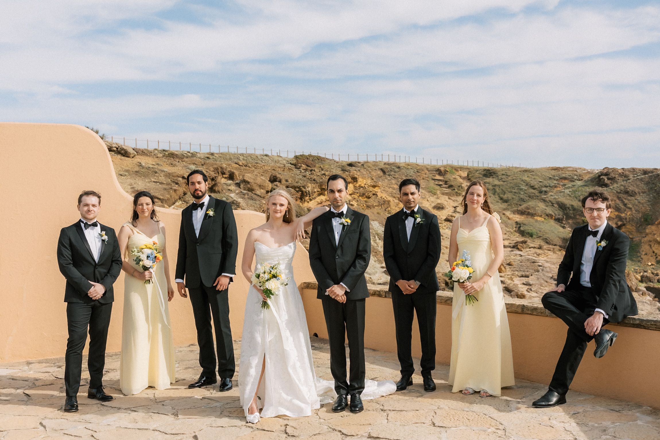 Bride, groom and bridal party celebrating together after the oceanfront wedding ceremony.