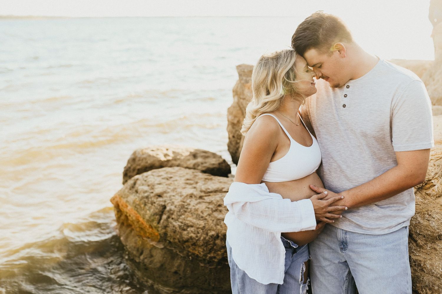 Summer maternity portrait of an expecting mother with wind blowing through her hair