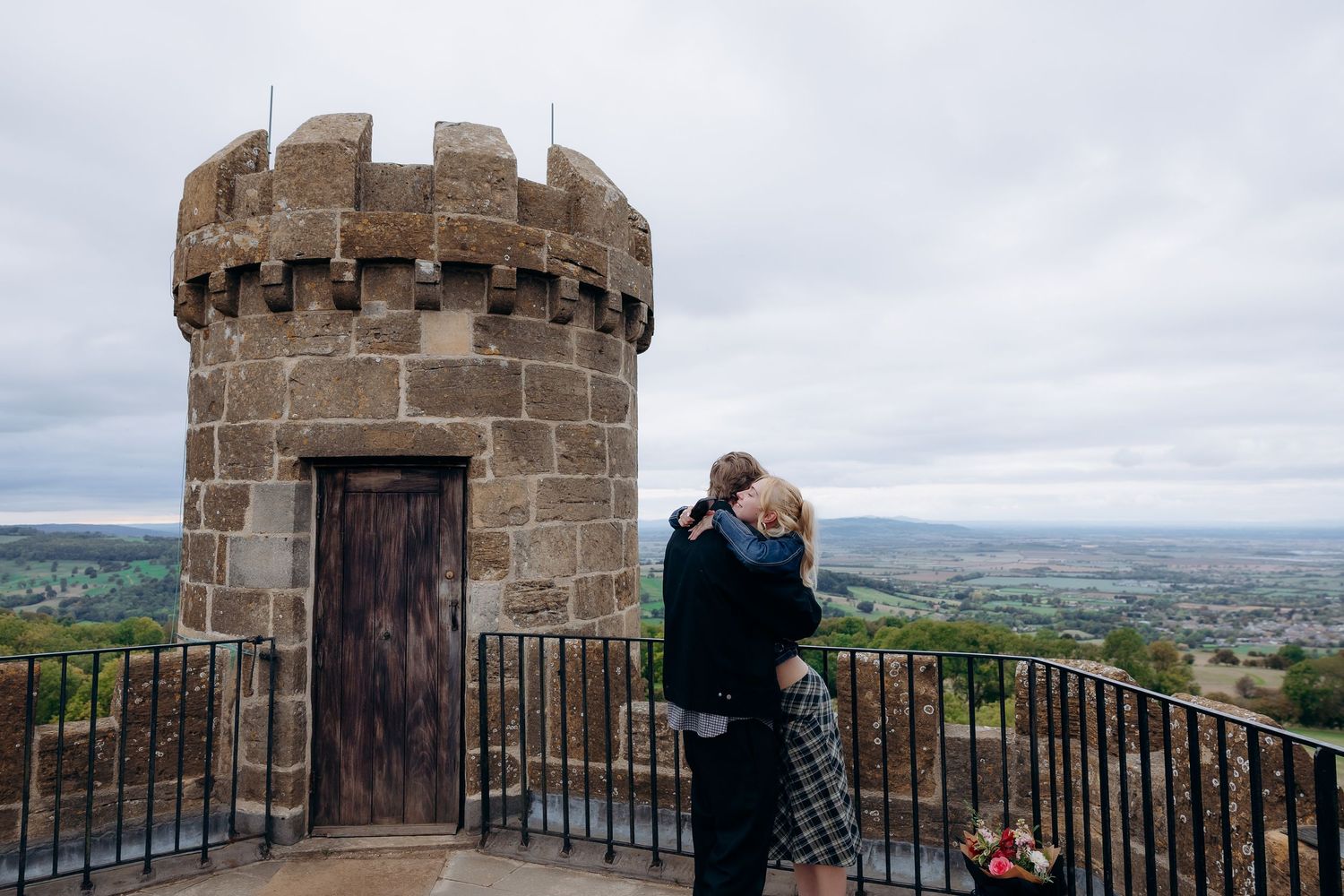 Romantic proposal at Broadway Tower during sunset.