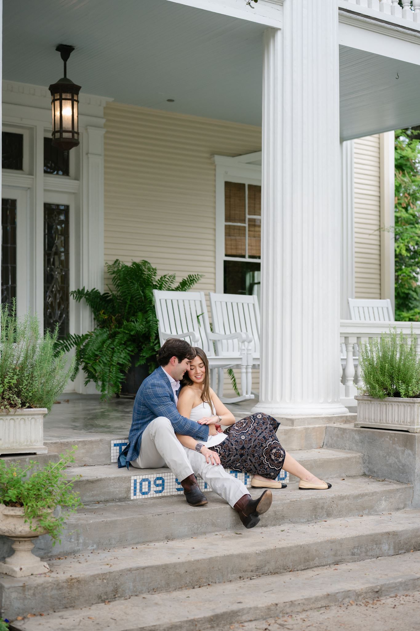 Newly engaged couple sharing an intimate moment on the stairs of a historic house in Houston.