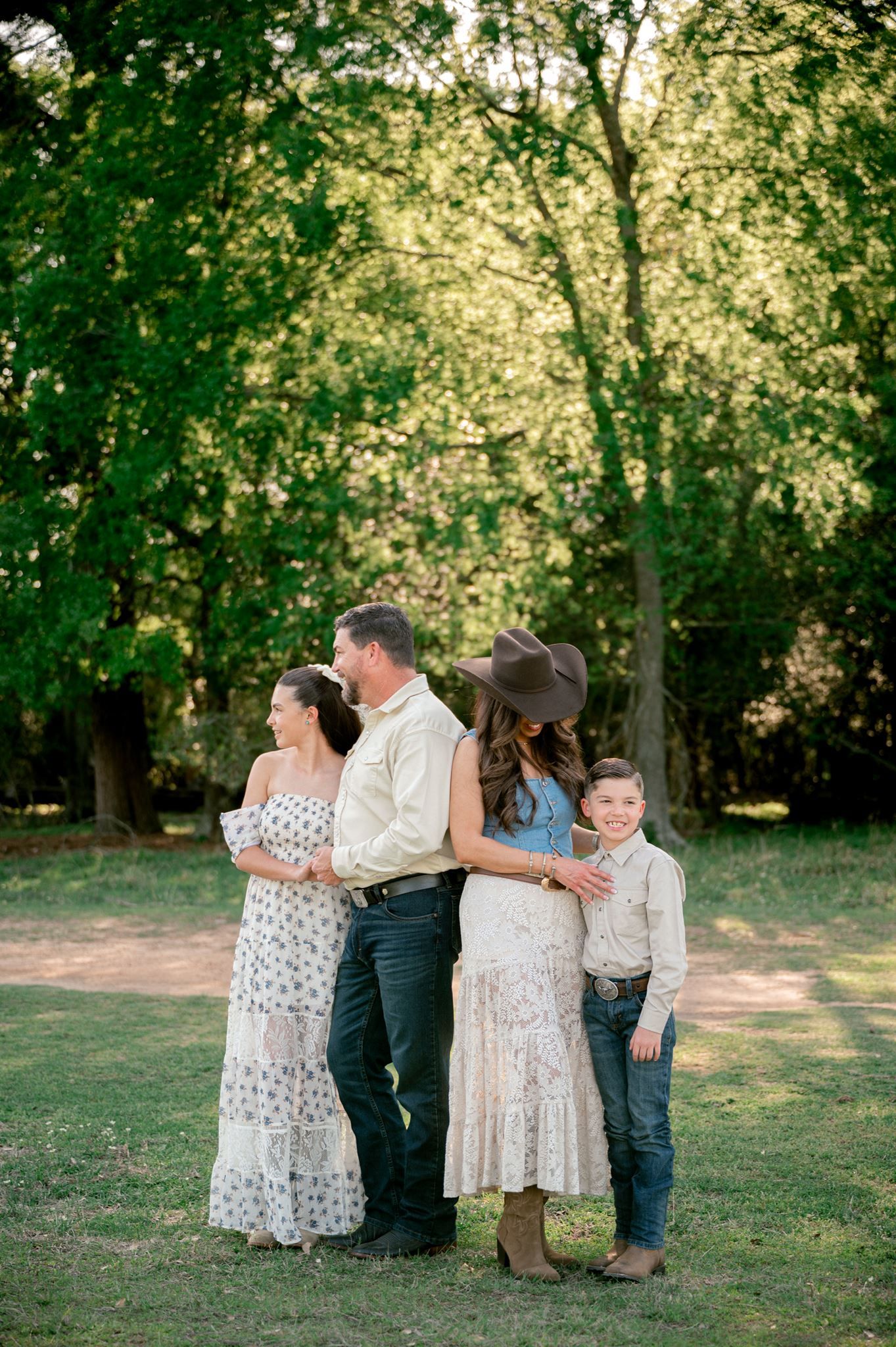 Family of four wearing western-inspired outfits during a lifestyle family photography session at Good Vibes Farm in Tomball, TX.