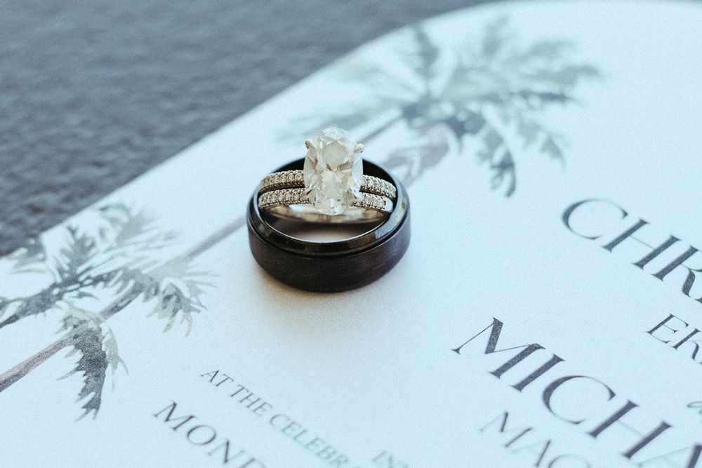 Wedding rings on a palm print invitation, intimate wedding detail photo by a Central NJ photographer