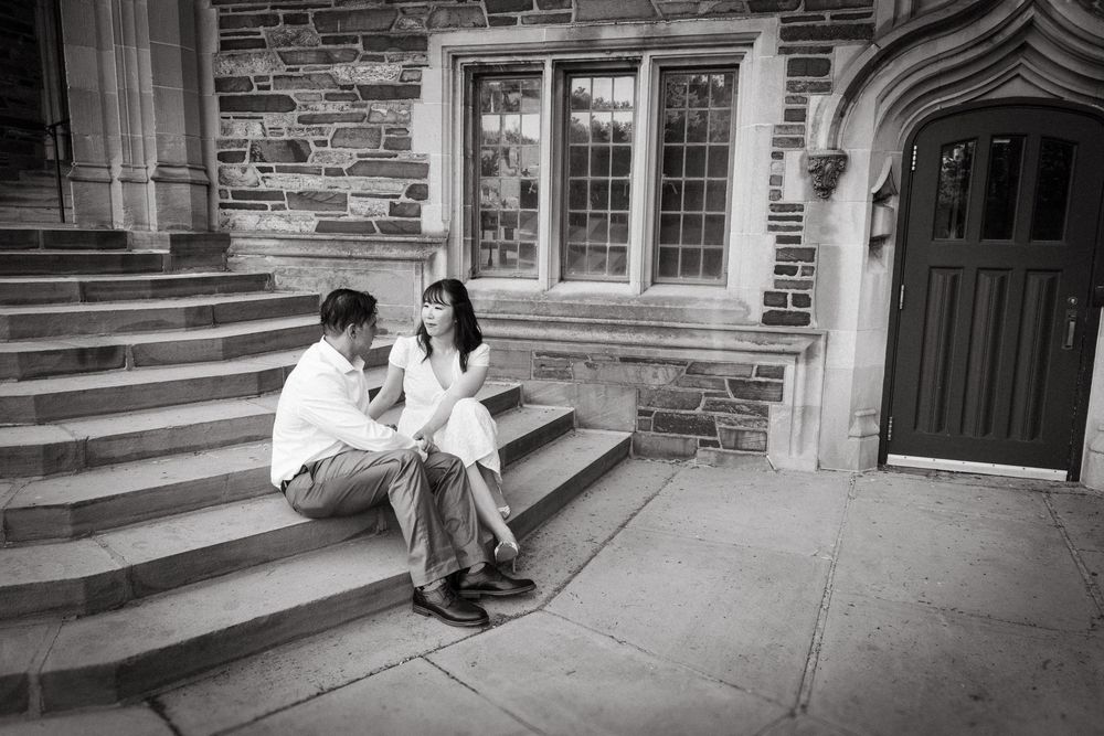 Black and white photo of a couple sitting on stone steps at Princeton University, NJ couples photography